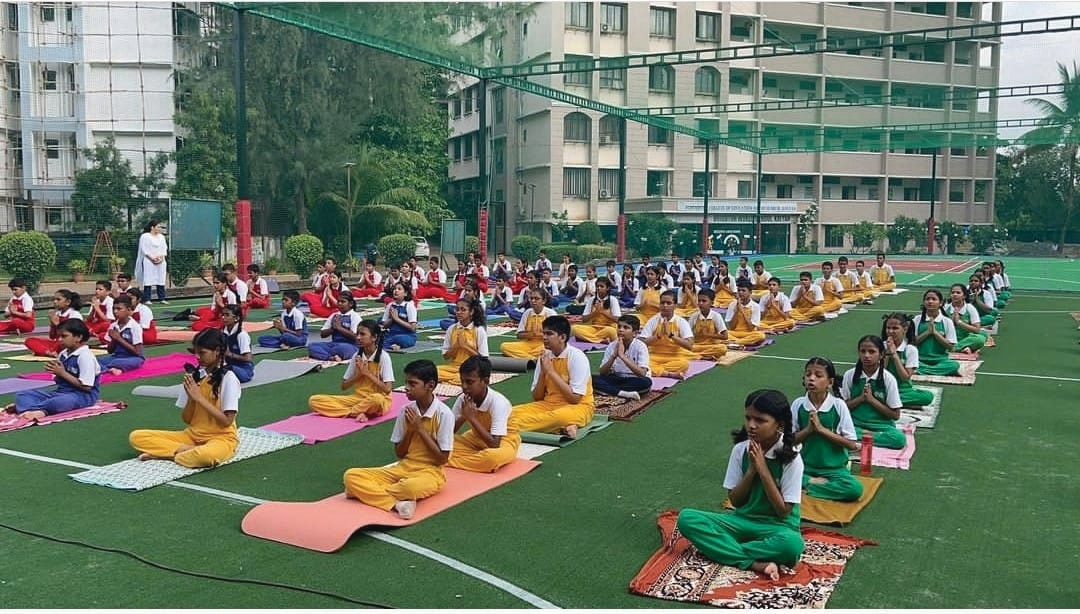 Students doing yoga on professional sports turf at SSPM Brighton campus, Kalyan
